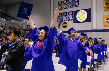 graduates cheer at commencement ceremony